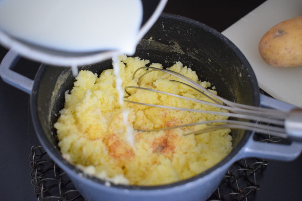 Milch hinzugeben um Kartoffelpüree zu machen