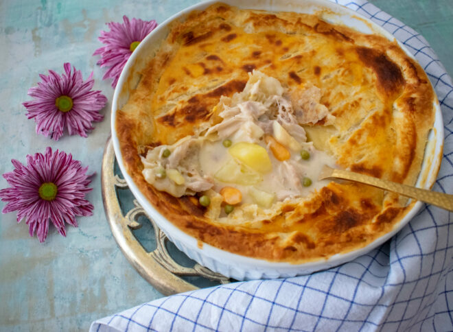 Kartoffelwürfel mit Hühnerfrikassee unter der Blätterteighaube